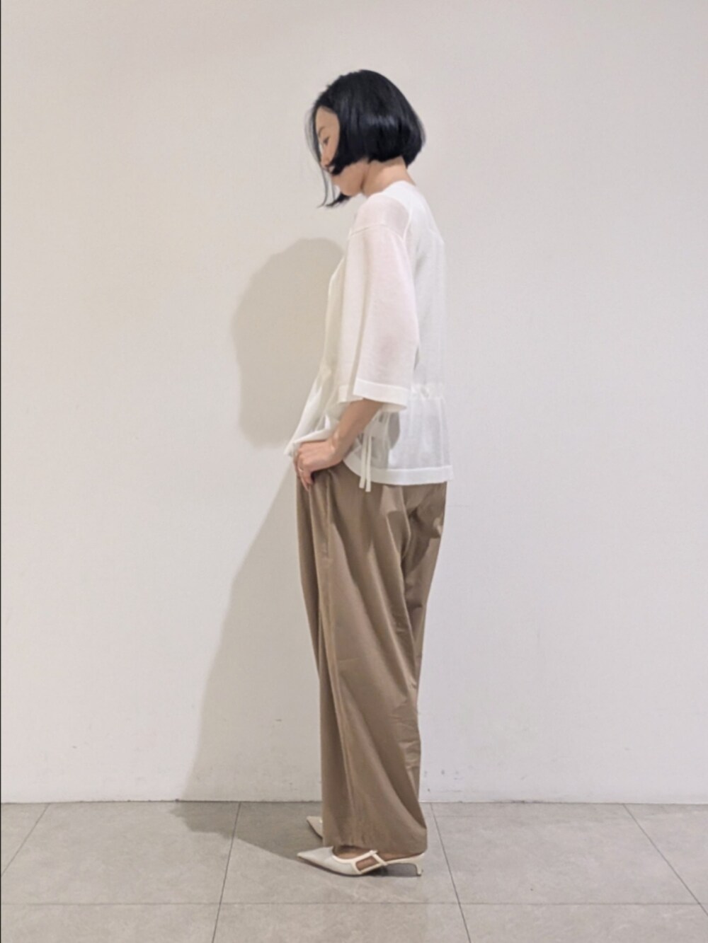 ホワイト系のブルゾン、ブラウン系のその他パンツ、ホワイト系のタンクトップを着用したレディースの夏コーディネートの4枚目の写真