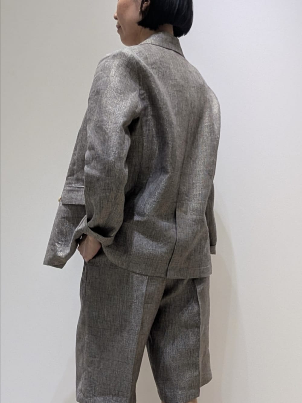 ベージュ系のテーラードジャケット、ベージュ系のその他パンツ、ホワイト系のタンクトップを着用したレディースの春コーディネートの4枚目の写真