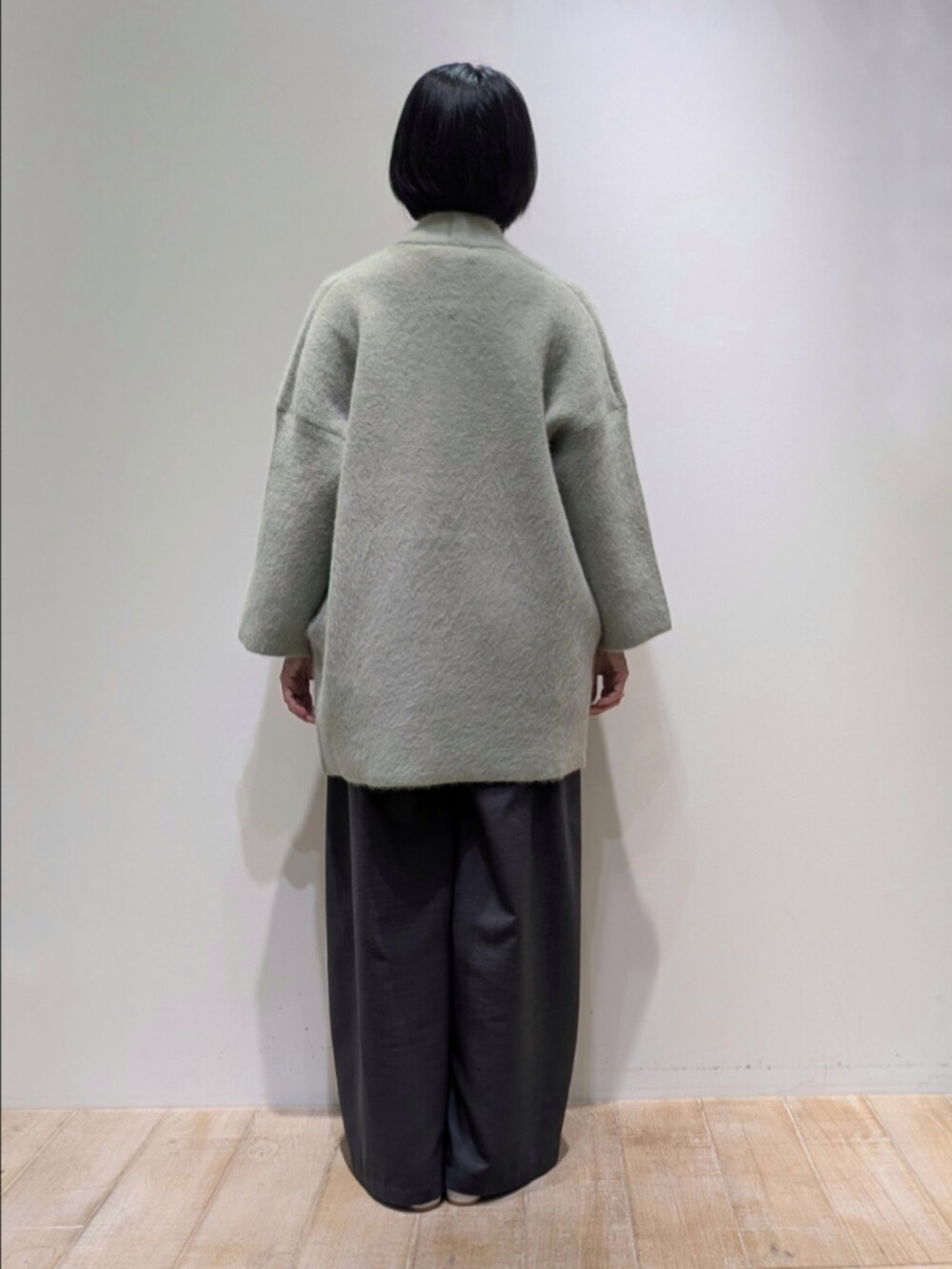 グリーン系のカーディガン/ボレロ、ホワイト系のシャツ/ブラウス、グレー系のその他パンツを着用したレディースの秋コーディネートの5枚目の写真