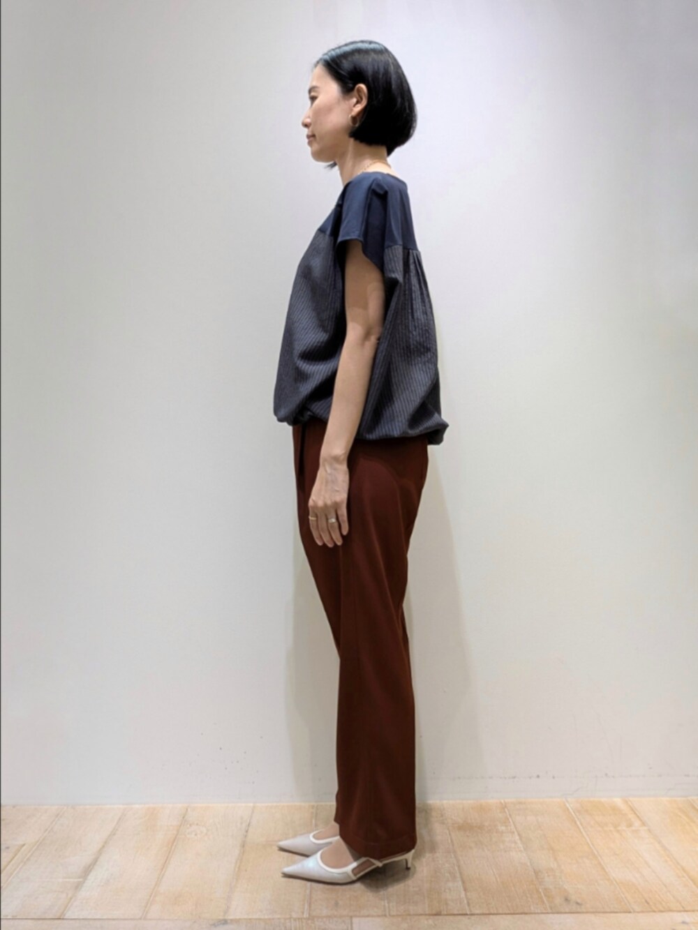 ブラウン系のその他パンツ、ブルー系のTシャツ/カットソー、ゴールド系のネックレスを着用したレディースの秋コーディネートの4枚目の写真