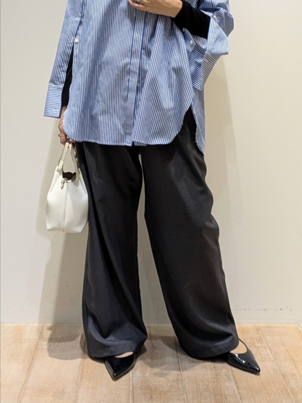 ブルー系のシャツ/ブラウス、ブラック系のニット/セーター、グレー系のその他パンツを着用したレディースの秋コーディネートの3枚目の写真