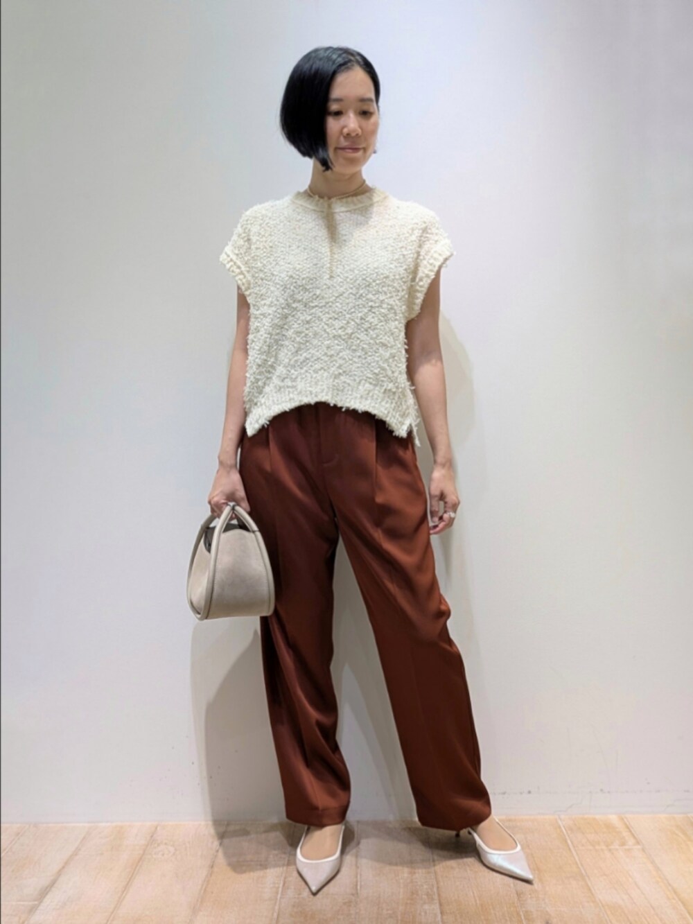 ホワイト系のニット/セーター、ブラウン系のその他パンツを着用したレディースの夏コーディネートの6枚目の写真