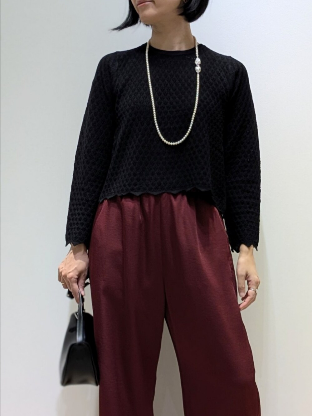 ブラック系のニット/セーター、レッド系のその他パンツを着用したレディースの秋コーディネートの2枚目の写真