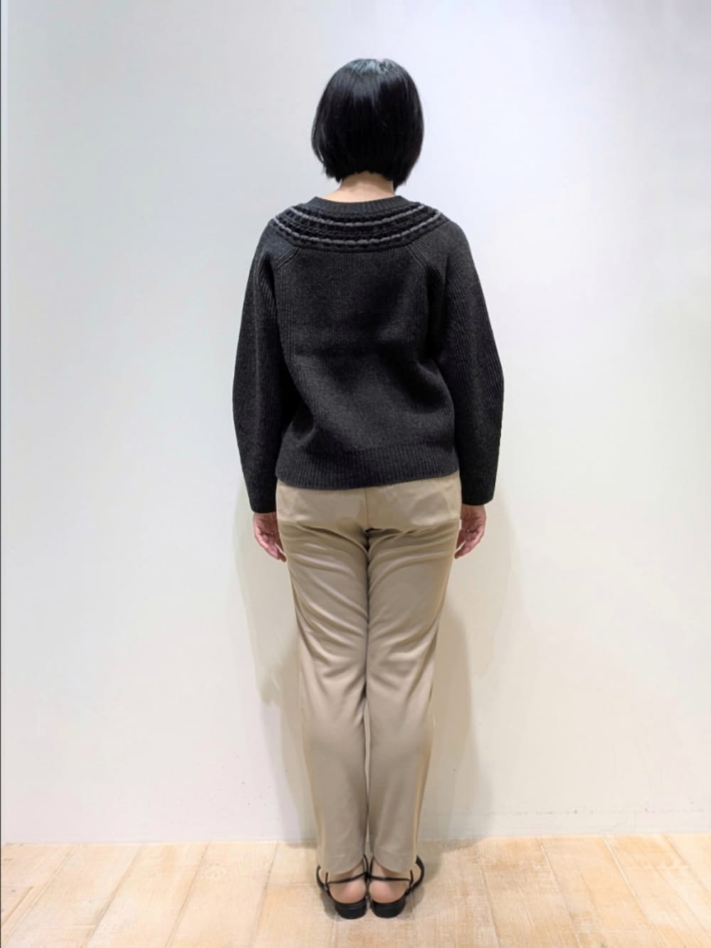グレー系のニット/セーター、ベージュ系のその他パンツ、ブラウン系のショルダーバッグを着用したレディースの秋コーディネートの5枚目の写真