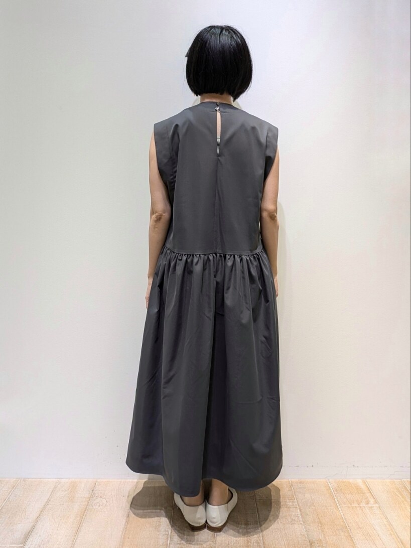 グレー系のワンピース、ゴールド系のネックレスを着用したレディースの夏コーディネートの2枚目の写真