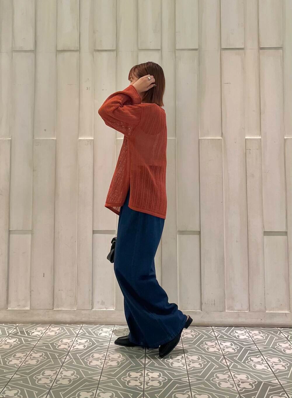 ブラック系のサンダル、ブラック系のショルダーバッグ、オレンジ系のニット/セーターを着用したレディースの秋コーディネートの3枚目の写真