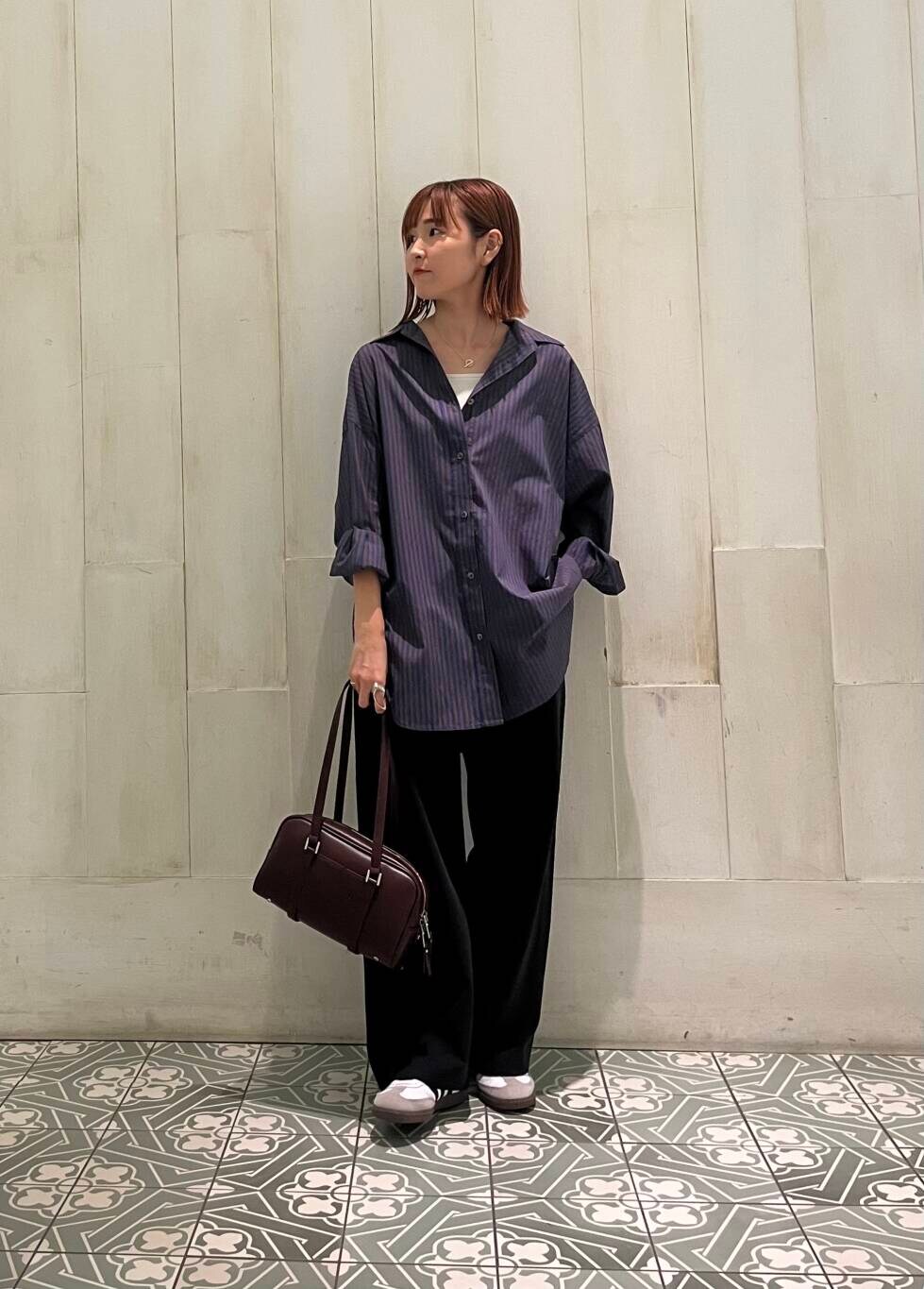 ホワイト系のスニーカー、ブラック系のその他パンツ、レッド系のボストンバッグを着用したレディースの秋コーディネートの2枚目の写真