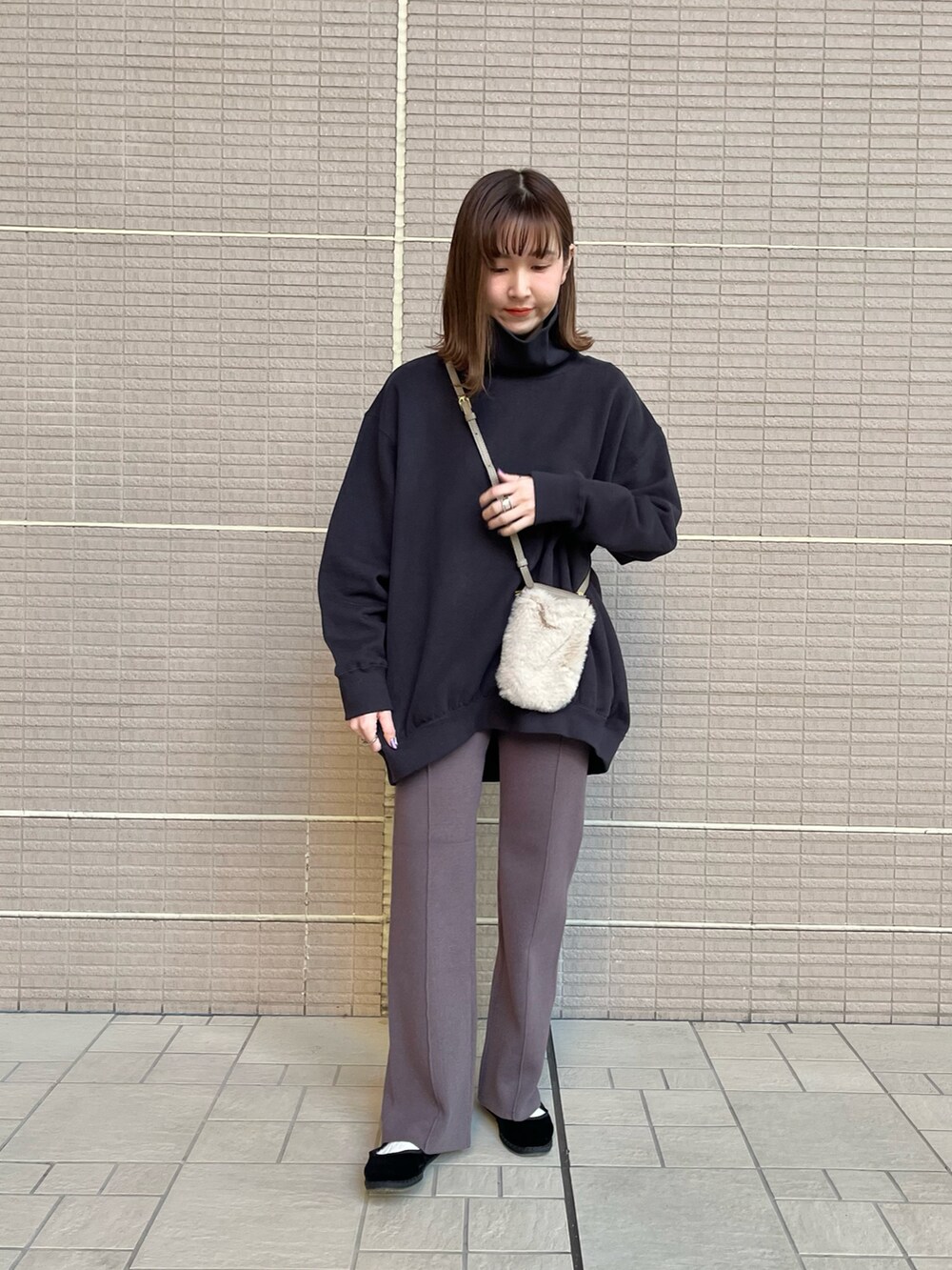 ブラック系のスウェット、ホワイト系のバッグ、グレー系のその他パンツを着用したレディースの冬コーディネートの2枚目の写真