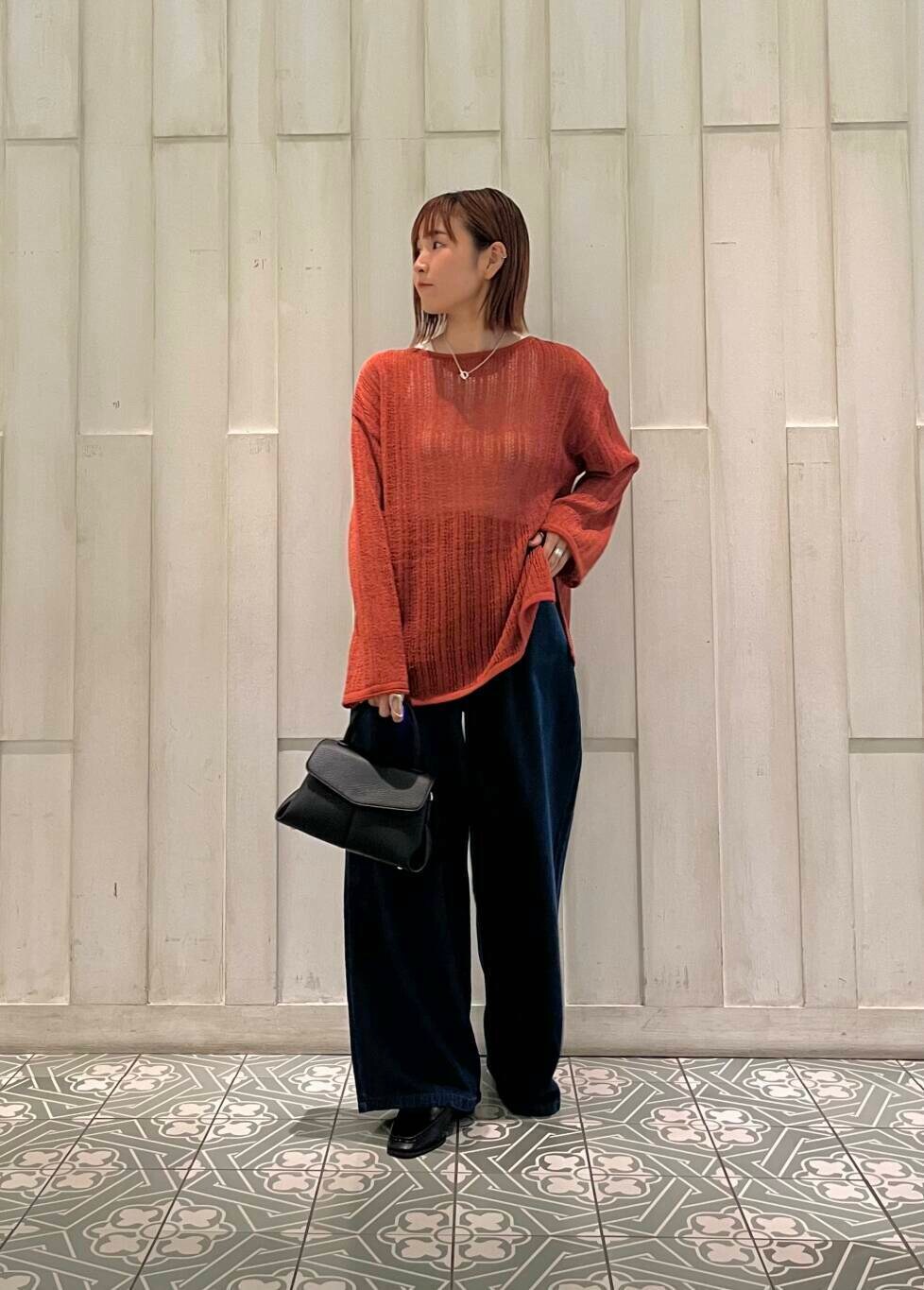 ブラック系のサンダル、ブラック系のショルダーバッグ、オレンジ系のニット/セーターを着用したレディースの秋コーディネートの2枚目の写真