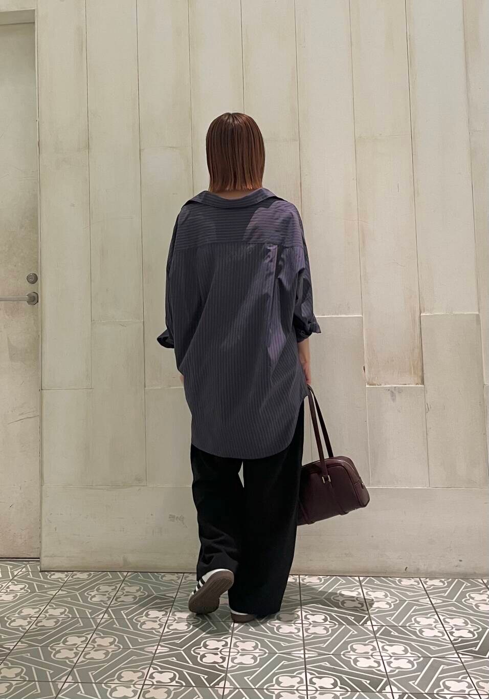 ホワイト系のスニーカー、ブラック系のその他パンツ、レッド系のボストンバッグを着用したレディースの秋コーディネートの4枚目の写真