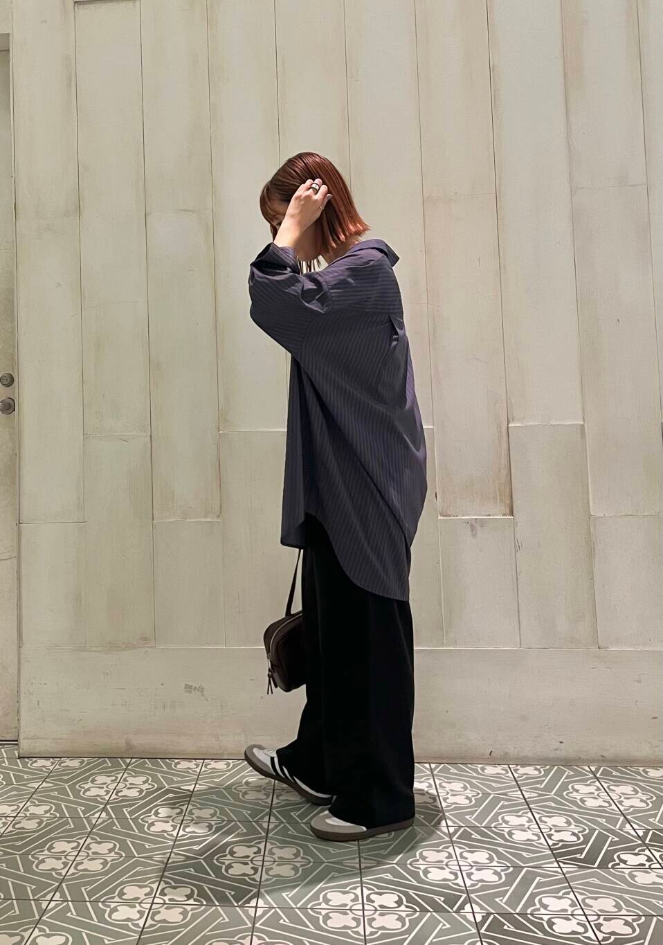 ホワイト系のスニーカー、ブラック系のその他パンツ、レッド系のボストンバッグを着用したレディースの秋コーディネートの3枚目の写真