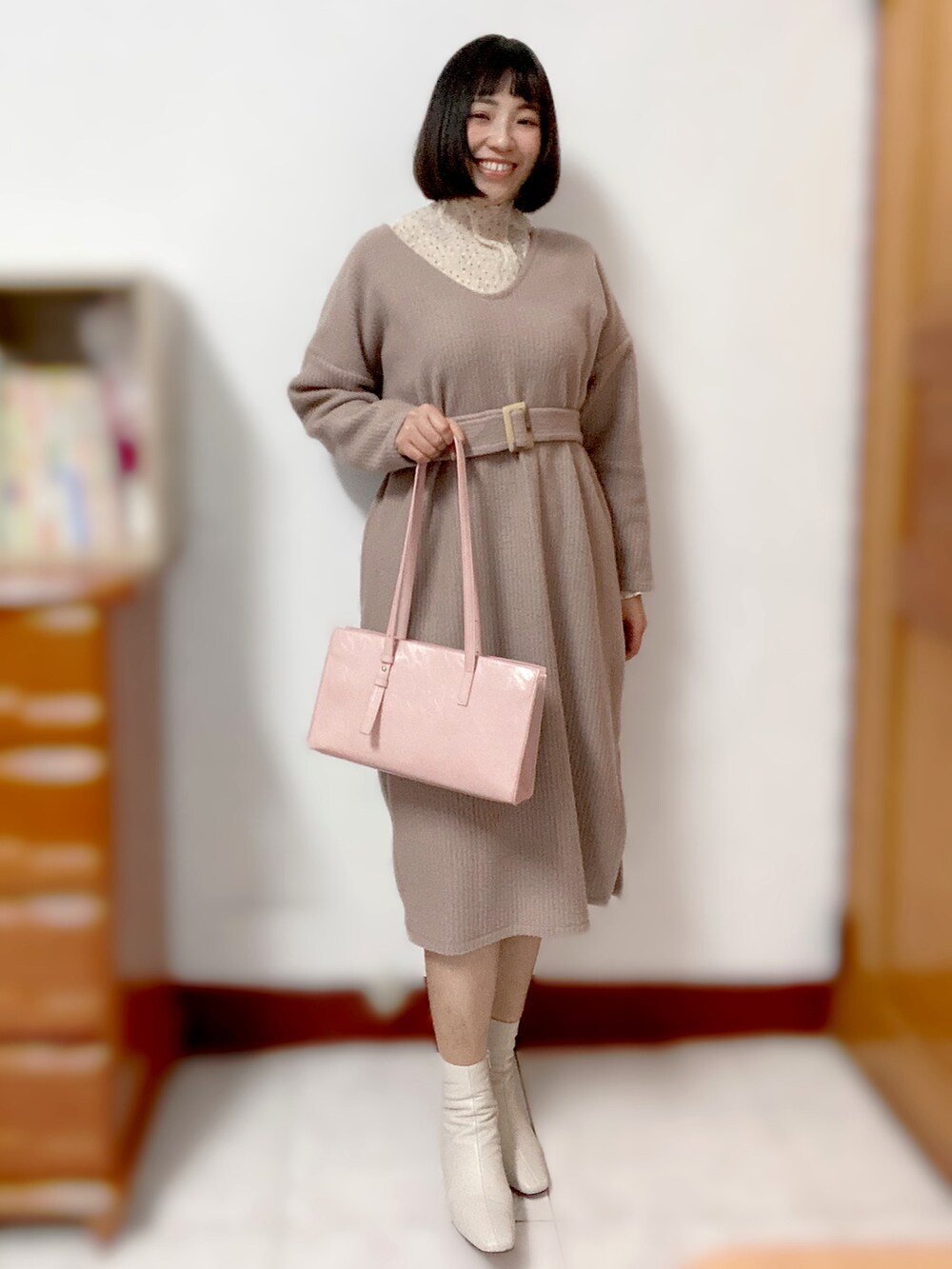 ベージュ系のトップス、ピンク系のワンピース/ドレス、ピンク系のショルダーバッグを着用したレディースの冬コーディネートの2枚目の写真