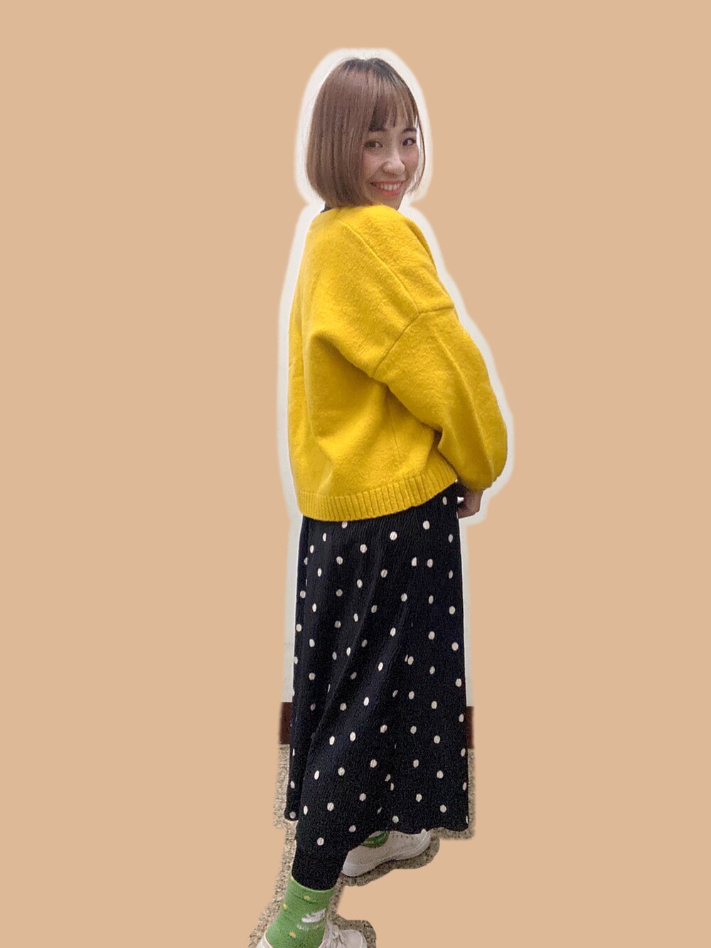イエロー系のノーカラージャケット、ホワイト系のトップス、ブラック系のスカートを着用したレディースの冬コーディネートの2枚目の写真