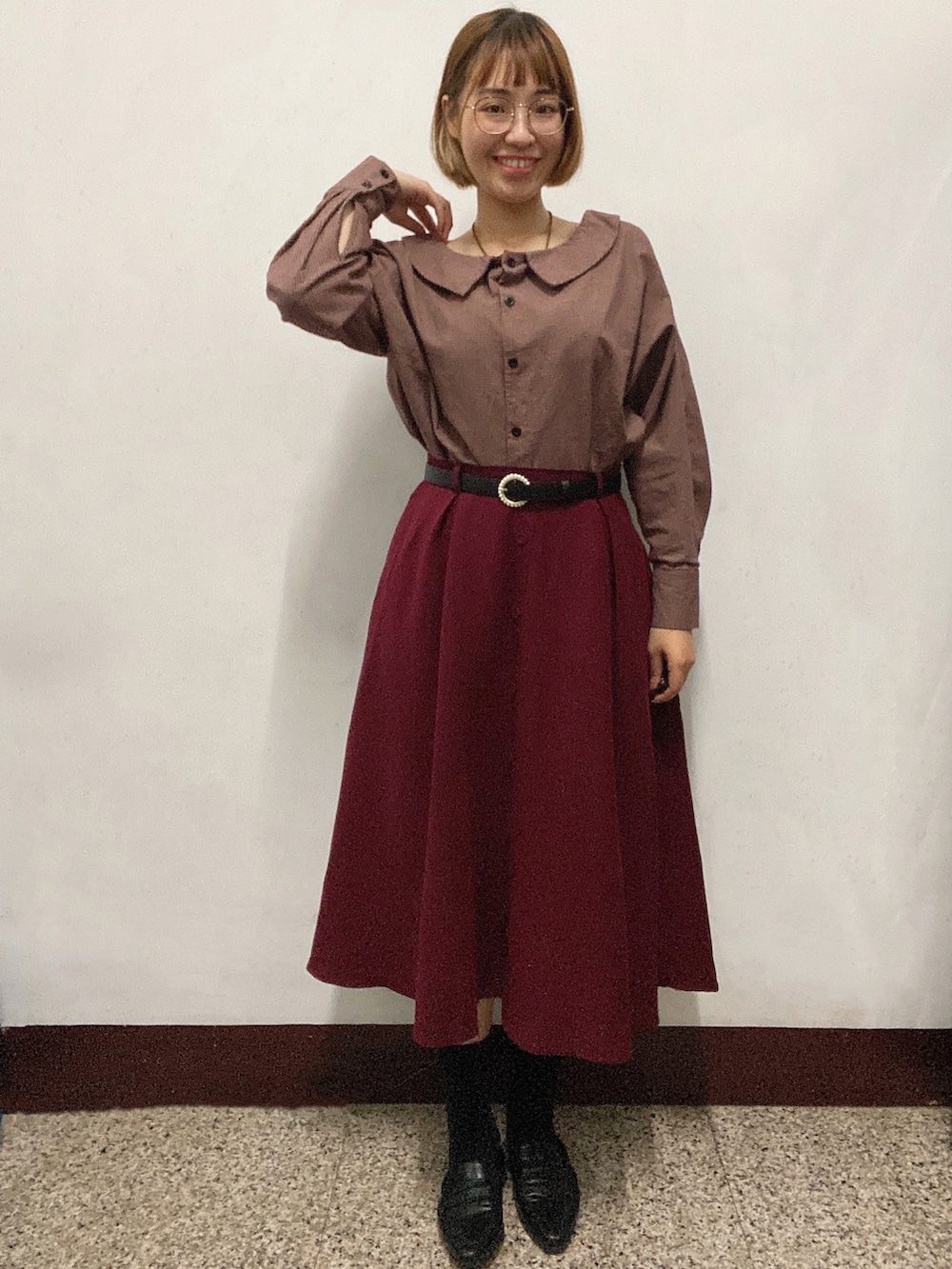 レッド系のトップス、ベージュ系のショルダーバッグ、ブラック系のスリッポンを着用したレディースの冬コーディネートの2枚目の写真