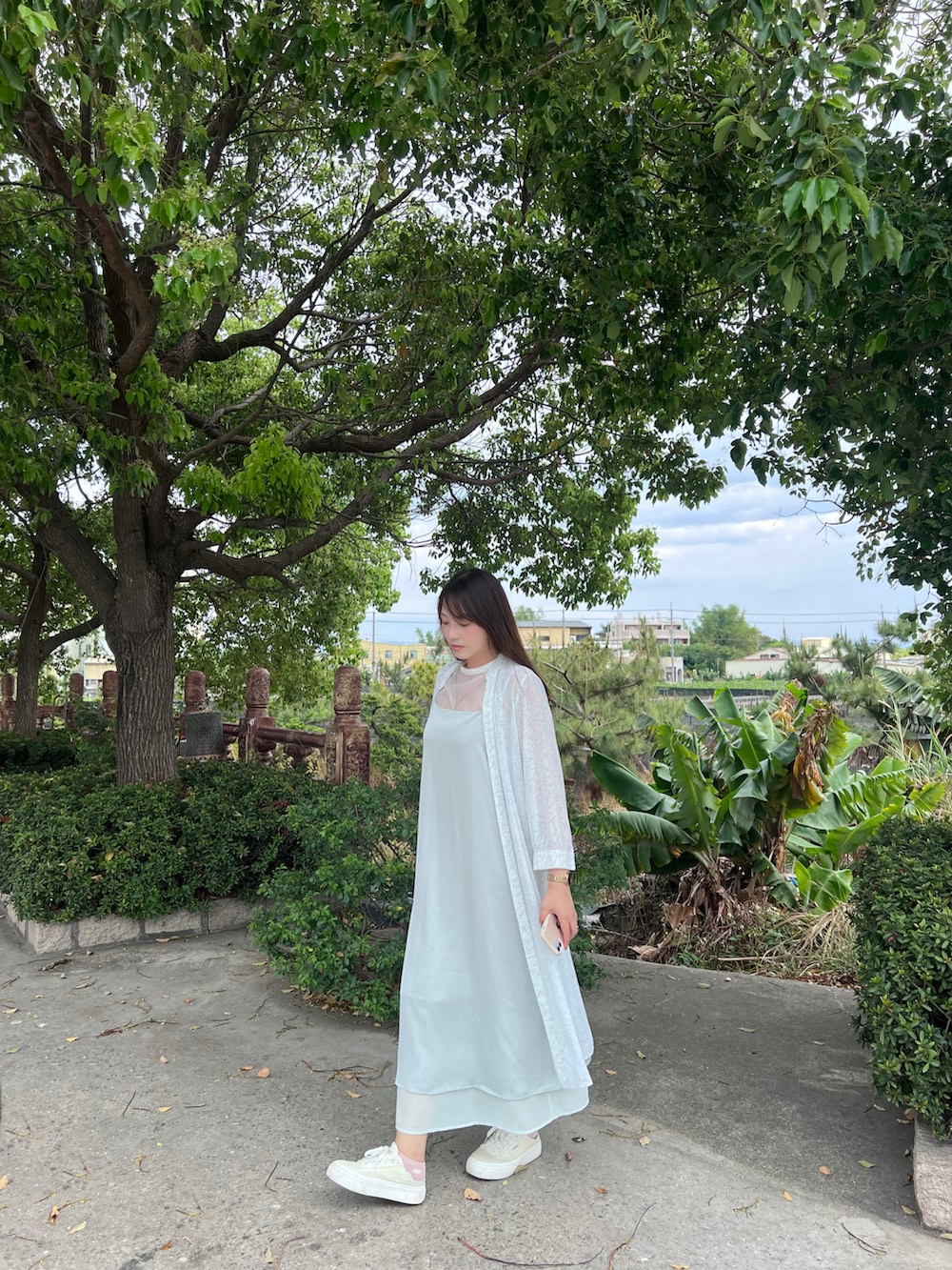 グリーン系のジャンパースカート、グリーン系のノーカラージャケット、イエロー系のスリッポンを着用したレディースの春コーディネートの2枚目の写真