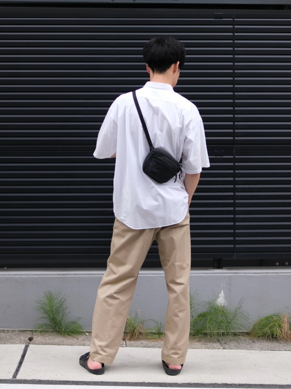 ホワイト系のシャツ/ブラウス、ベージュ系のチノパンツ、ブラック系のサンダルを着用したメンズの夏コーディネートの2枚目の写真