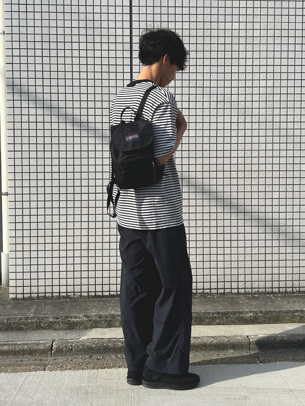 ブラック系のシャツ/ブラウス、ブラック系のバックパック/リュック、ブルー系のその他パンツを着用したメンズの夏コーディネートの2枚目の写真