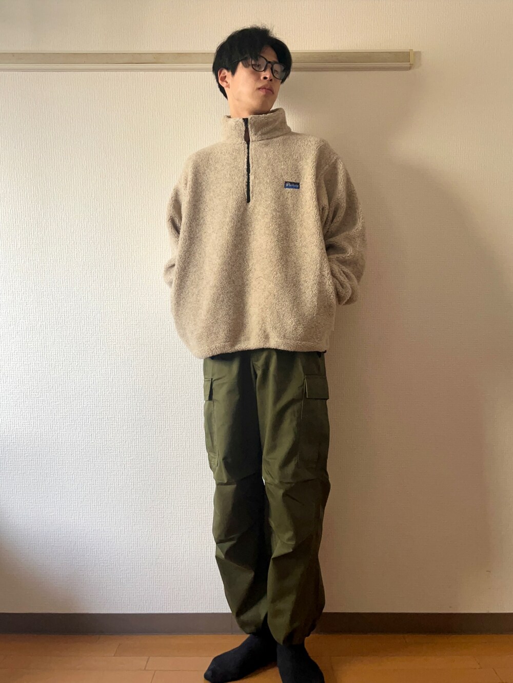 ベージュ系のその他アウター、ブラウン系のTシャツ/カットソー、グリーン系のカーゴパンツを着用したメンズの冬コーディネートの4枚目の写真