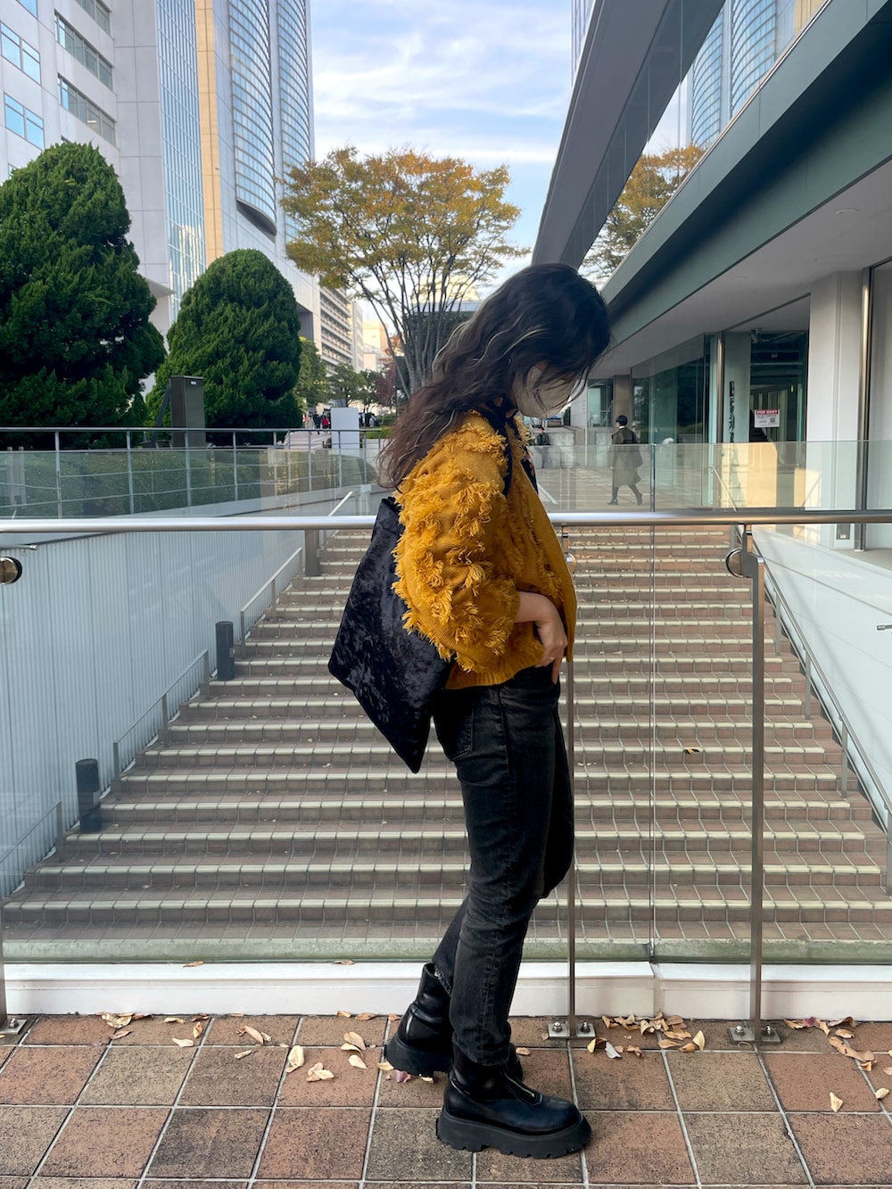 ブラック系のデニムパンツ、ブラック系のブーツ、ブラック系のエコバッグ/サブバッグを着用したレディースの冬コーディネートの2枚目の写真