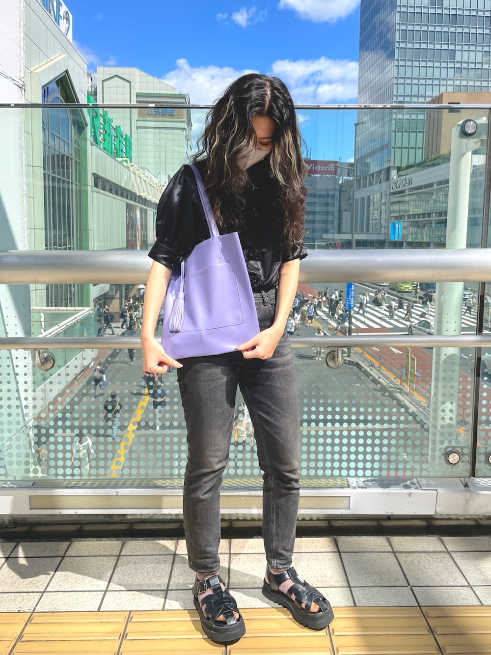 パープル系のトートバッグ、ブラック系のシャツ/ブラウス、ブラック系のデニムパンツを着用したレディースの秋コーディネートの2枚目の写真