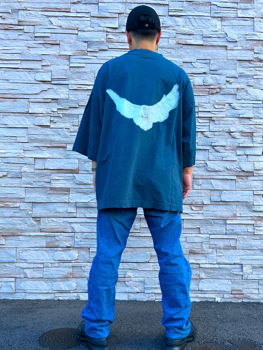 ブルー系のTシャツ/カットソー、ブルー系のデニムパンツ、ブラック系のスニーカーを着用したメンズの秋コーディネートの2枚目の写真