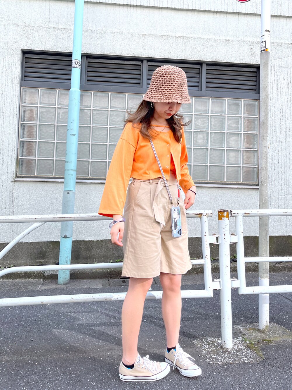 オレンジ系のカーディガン/ボレロ、ベージュ系のその他パンツ、ブルー系のその他を着用したレディースの春コーディネートの2枚目の写真