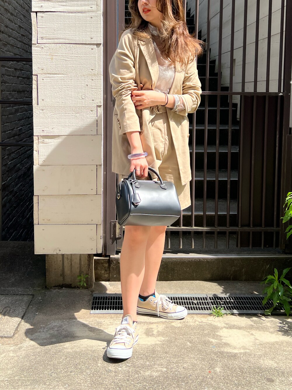 ベージュ系のテーラードジャケット、ベージュ系のその他パンツ、ブラック系のショルダーバッグを着用したレディースの春コーディネートの2枚目の写真