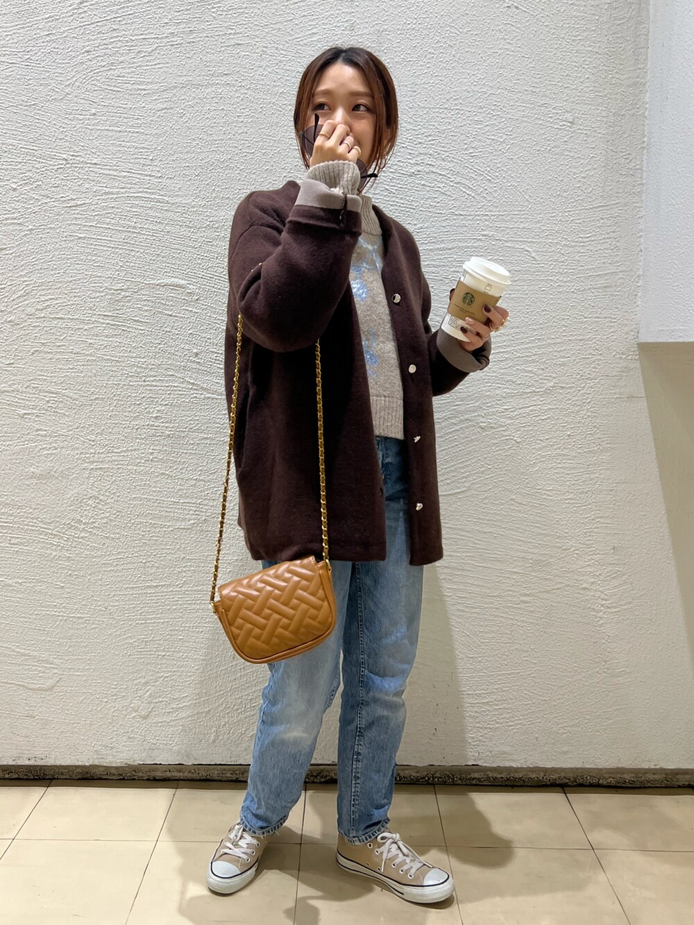 ブラウン系のニット/セーター、イエロー系のショルダーバッグ、ブラウン系のノーカラーコートを着用したレディースの秋コーディネートの2枚目の写真