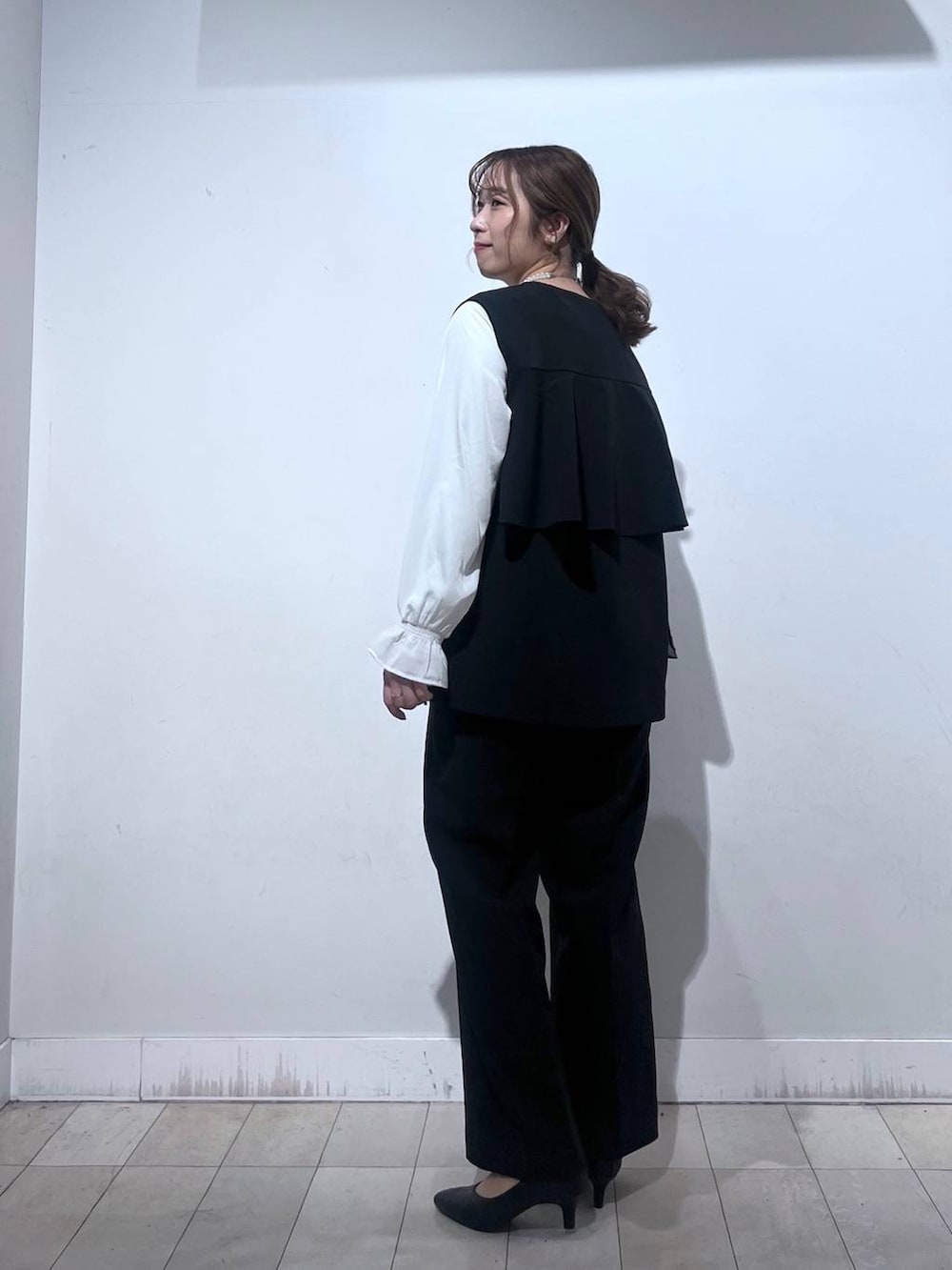 ブラック系のパンプス、ブルー系のセットアップ、ブラック系のショルダーバッグを着用したレディースの冬コーディネートの5枚目の写真