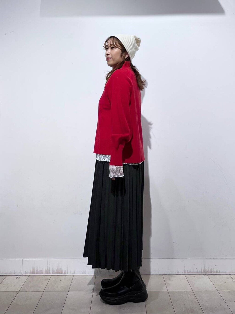 ブラック系のダウンジャケット/コート、ホワイト系のTシャツ/カットソー、レッド系のニット/セーターを着用したレディースの冬コーディネートの3枚目の写真