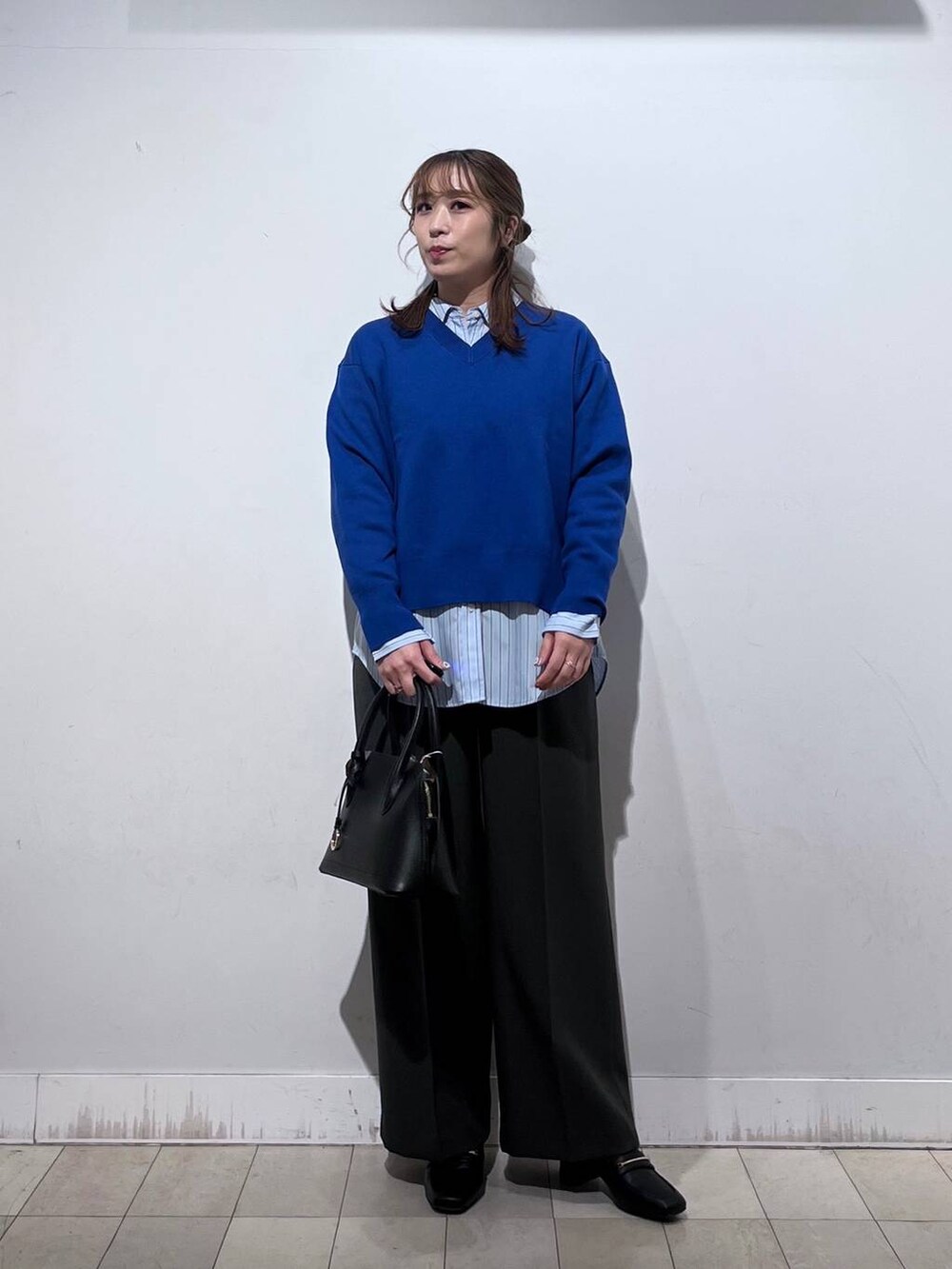 ブラック系のローファー、ブラック系のショルダーバッグ、ブルー系のシャツ/ブラウスを着用したレディースの冬コーディネートの2枚目の写真