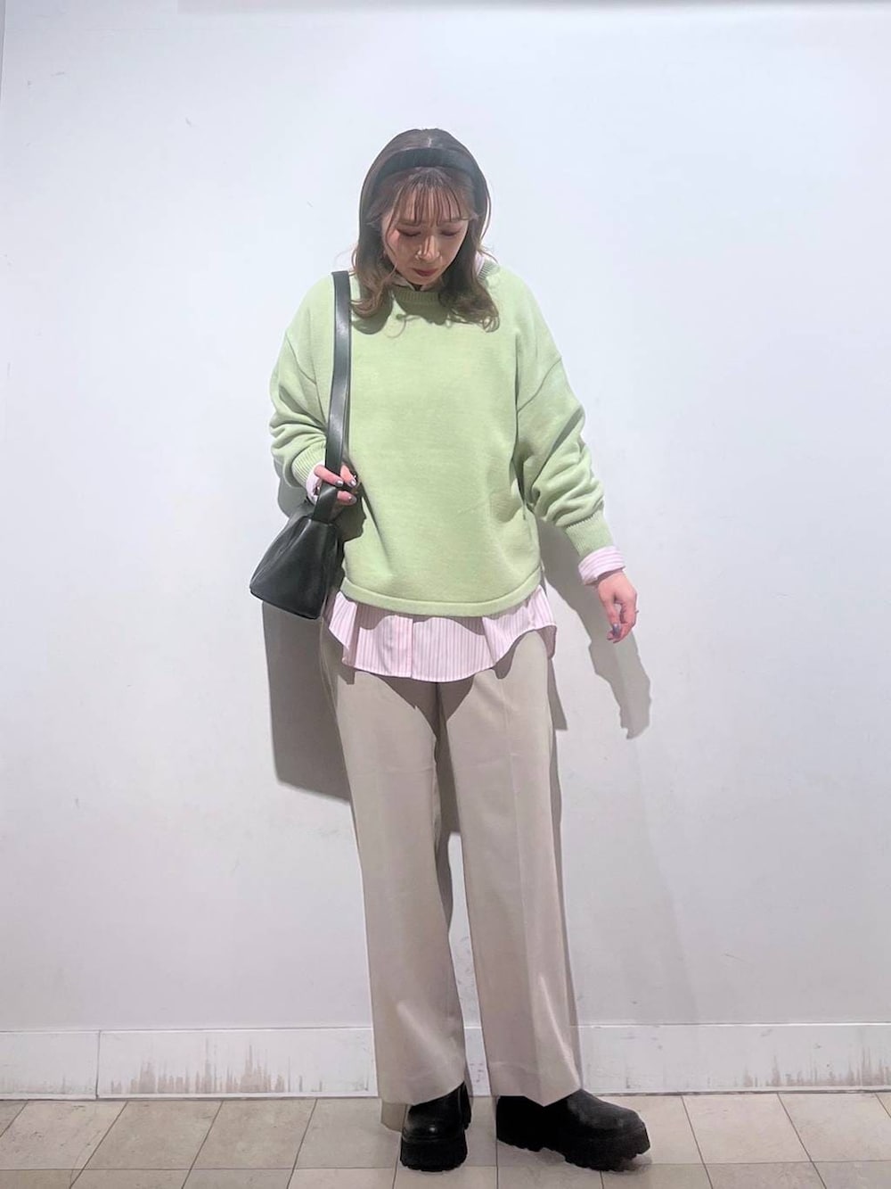 グリーン系のニット/セーター、ピンク系のシャツ/ブラウス、ベージュ系のスラックスを着用したレディースの春コーディネートの4枚目の写真