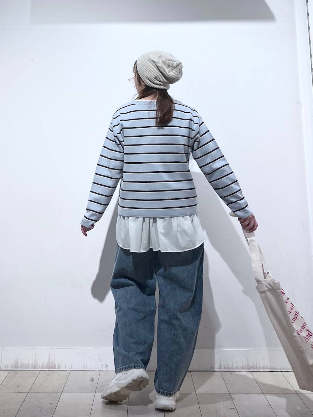 ホワイト系のTシャツ/カットソー、ホワイト系のトートバッグ、ブルー系のニット/セーターを着用したレディースの冬コーディネートの4枚目の写真