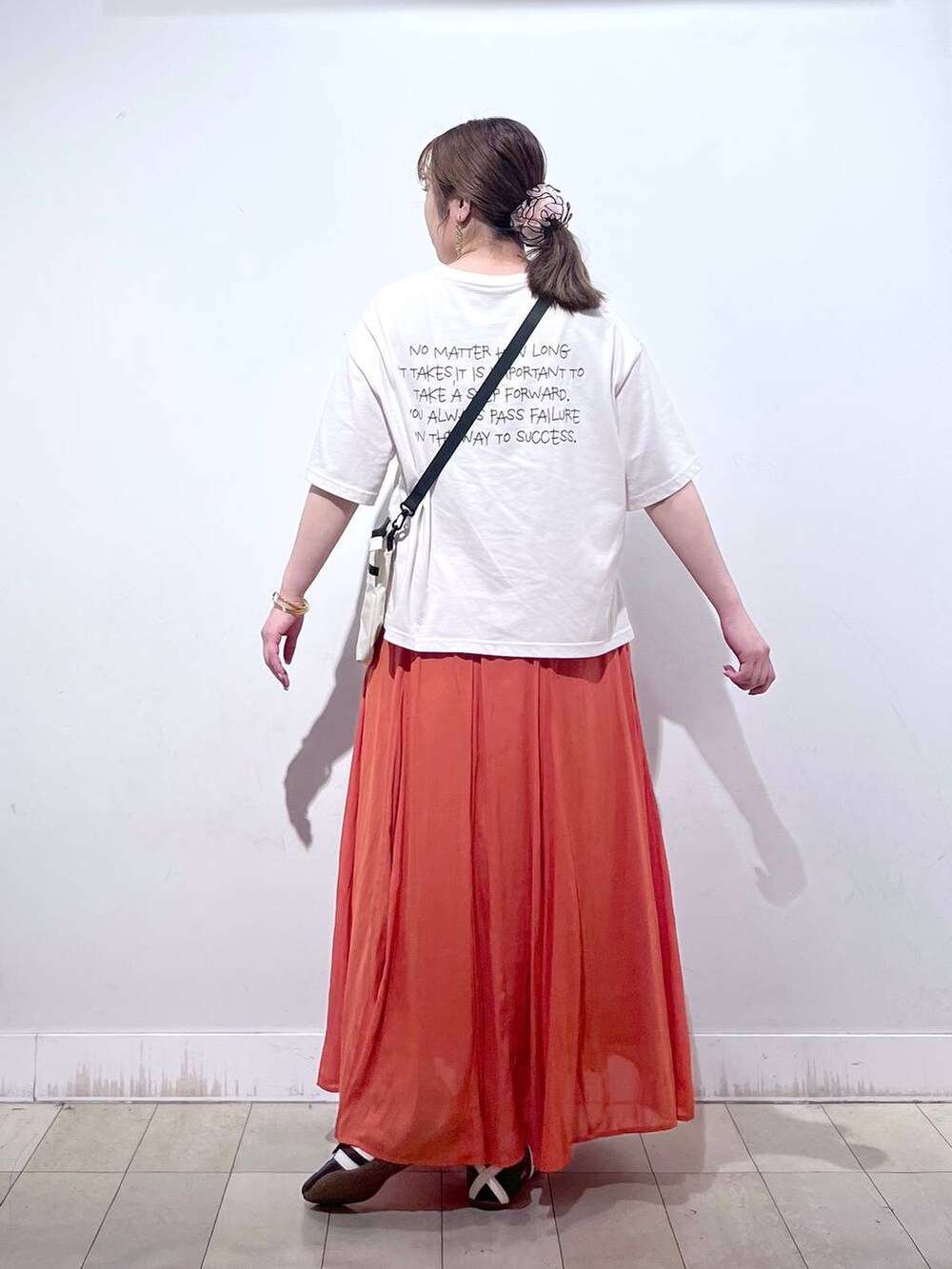 オレンジ系のスカート、ベージュ系のTシャツ/カットソー、ホワイト系のタンクトップを着用したレディースの夏コーディネートの4枚目の写真