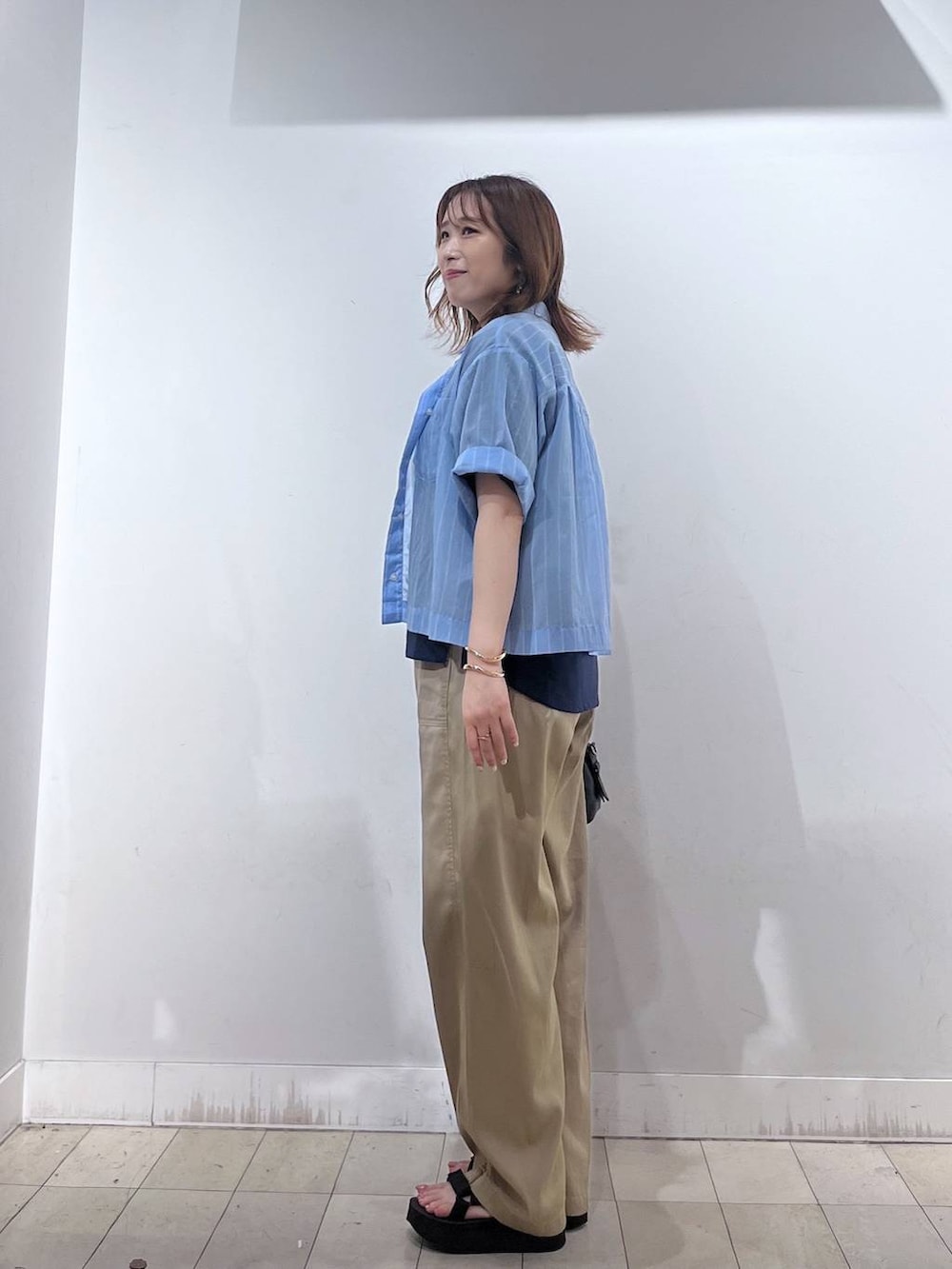 ブルー系のシャツ/ブラウス、ブルー系のTシャツ/カットソー、ブラック系のボストンバッグを着用したレディースの夏コーディネートの2枚目の写真