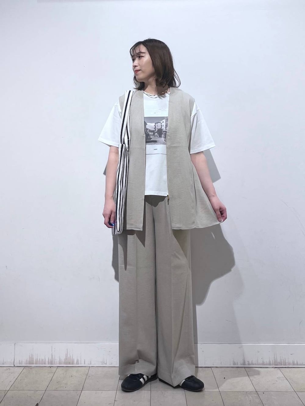 ホワイト系のトートバッグ、ベージュ系のベスト、ベージュ系のその他パンツを着用したレディースの夏コーディネートの4枚目の写真