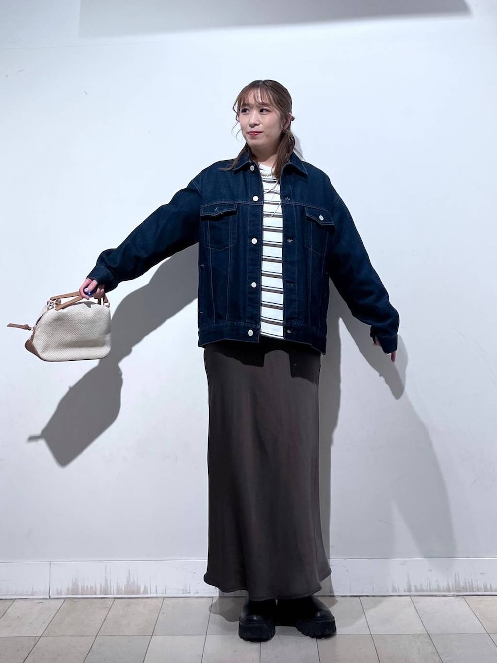 ホワイト系のショルダーバッグ、ブルー系のデニムジャケット、ブラウン系のスカートを着用したレディースの冬コーディネートの7枚目の写真