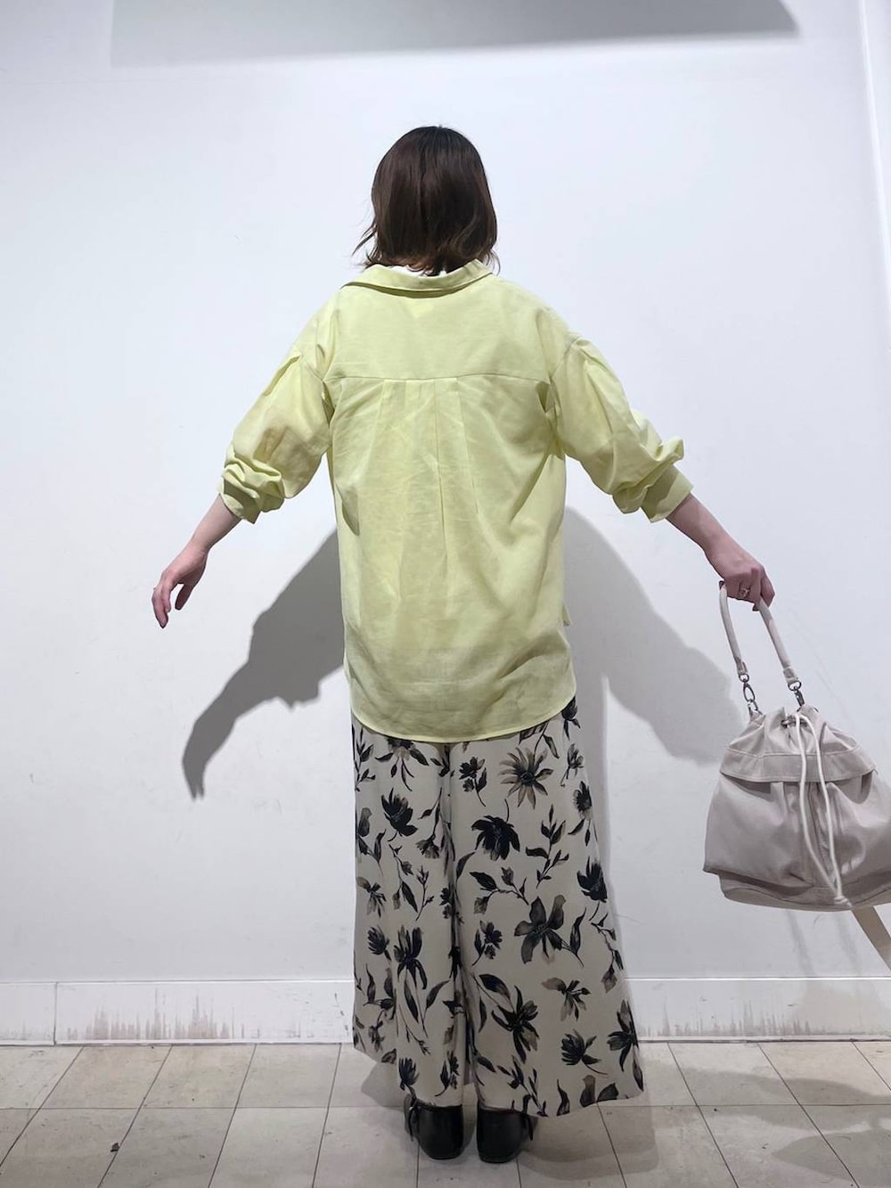 ホワイト系のショルダーバッグ、ホワイト系のTシャツ/カットソー、イエロー系のシャツ/ブラウスを着用したレディースの春コーディネートの6枚目の写真