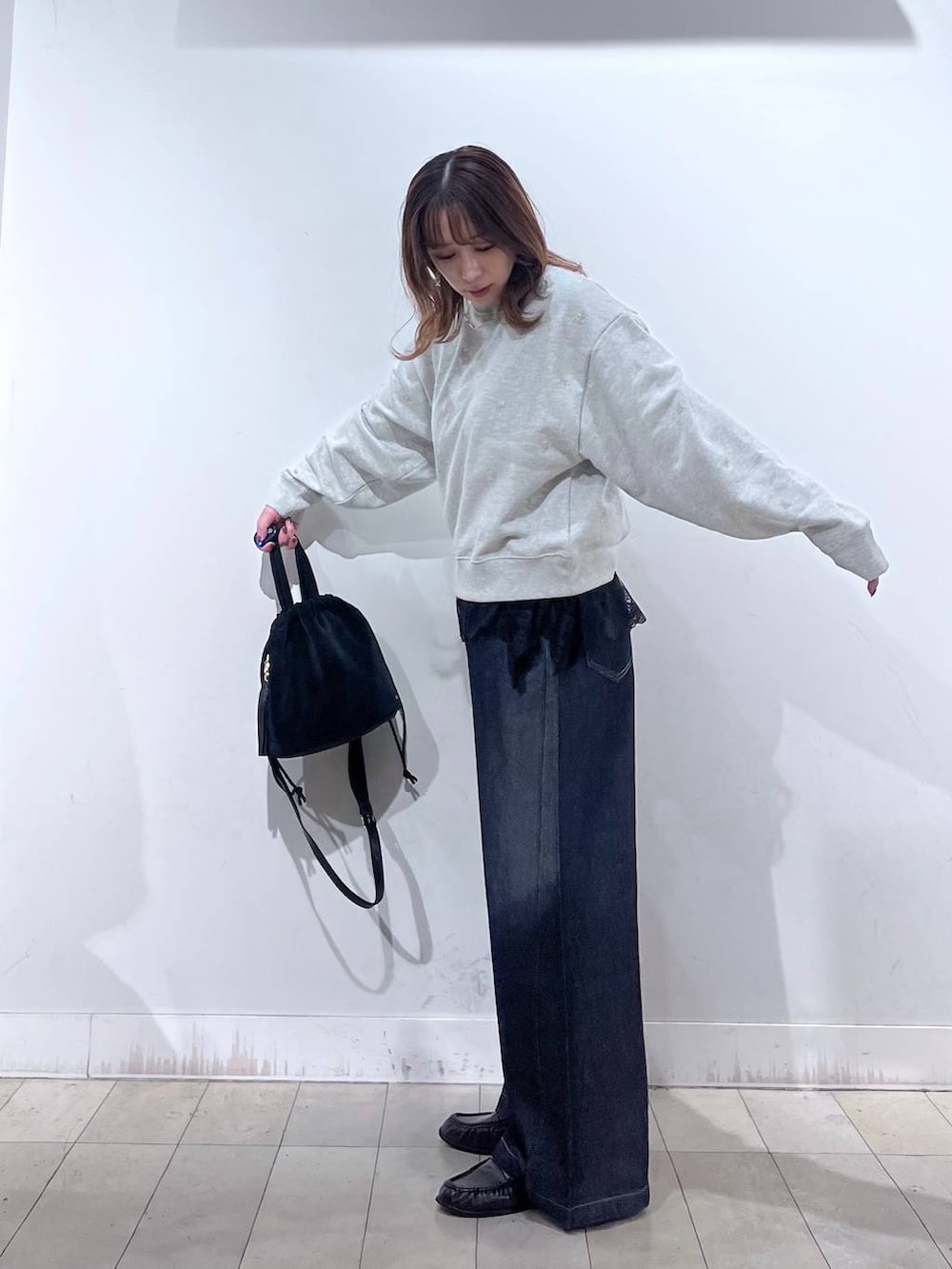 ブラック系のハンドバッグ、グレー系のTシャツ/カットソー、ブラウン系のローファーを着用したレディースの秋コーディネートの5枚目の写真