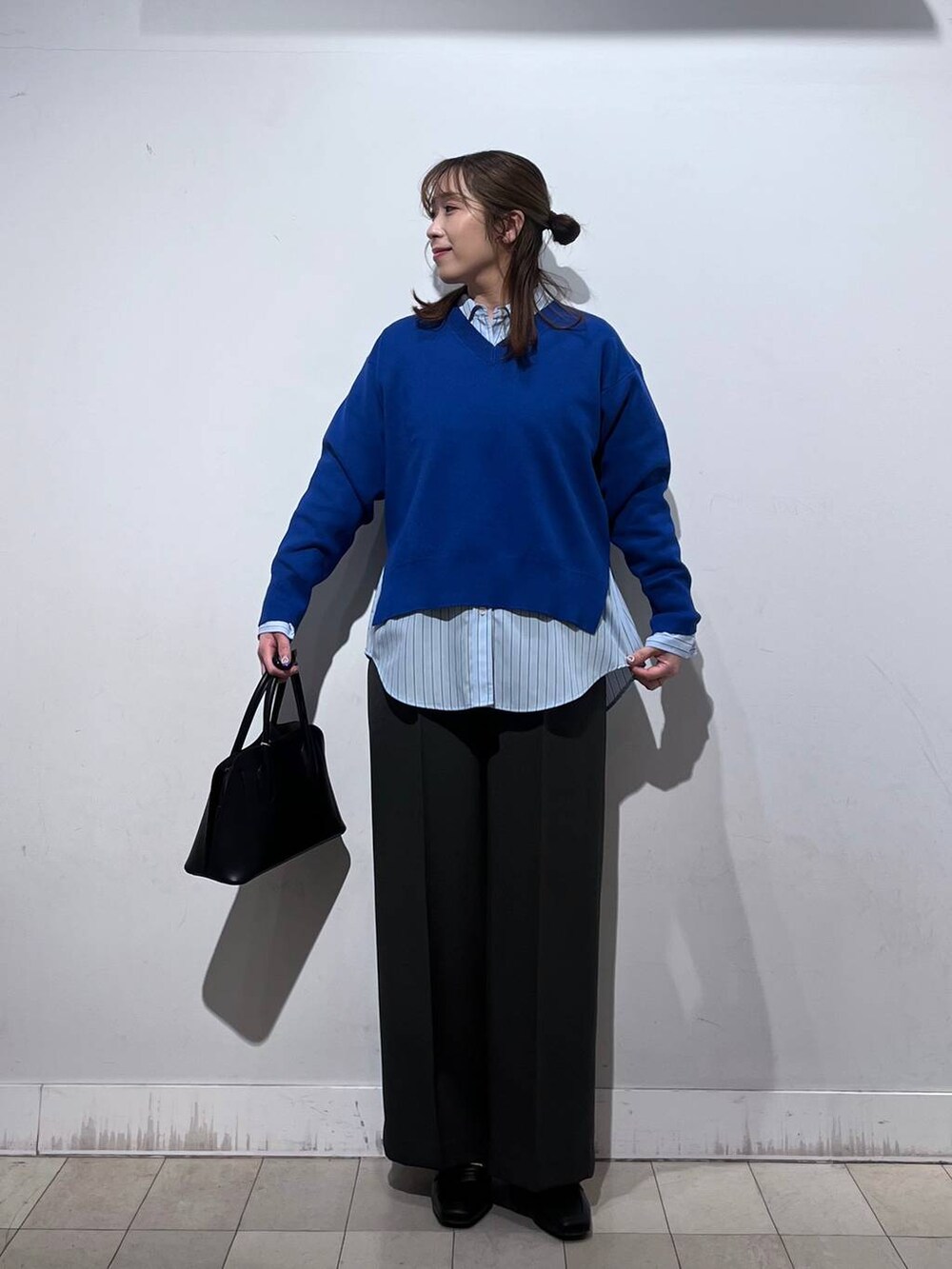 ブラック系のローファー、ブラック系のショルダーバッグ、ブルー系のシャツ/ブラウスを着用したレディースの冬コーディネートの4枚目の写真