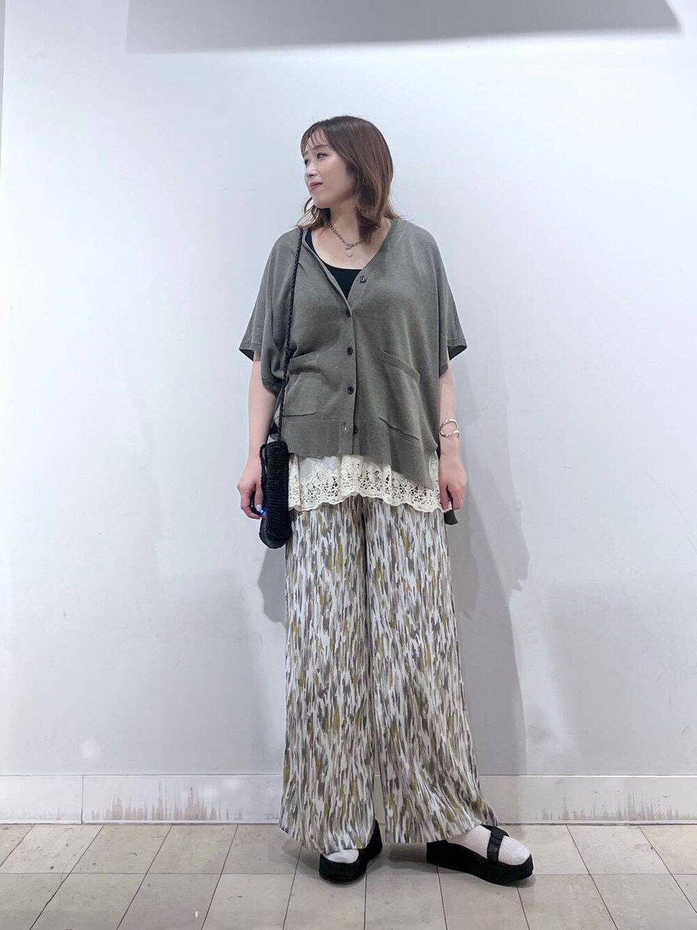 ブラウン系のカーディガン/ボレロ、ベージュ系のその他パンツ、ホワイト系のその他トップスを着用したレディースの夏コーディネートの4枚目の写真