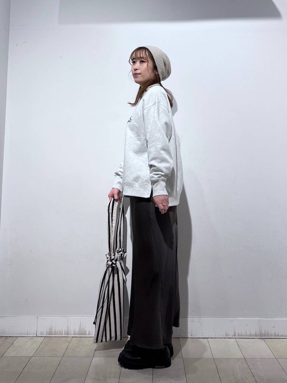 ホワイト系のTシャツ/カットソー、グレー系のスウェット、ベージュ系のトートバッグを着用したレディースの春コーディネートの2枚目の写真