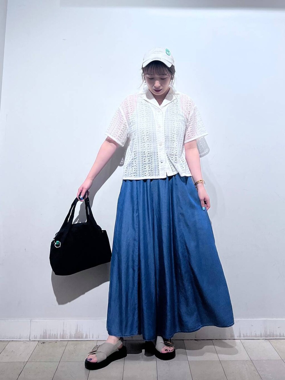 ブラック系のトートバッグ、ブルー系のその他パンツ、ベージュ系のサンダルを着用したレディースの夏コーディネートの9枚目の写真