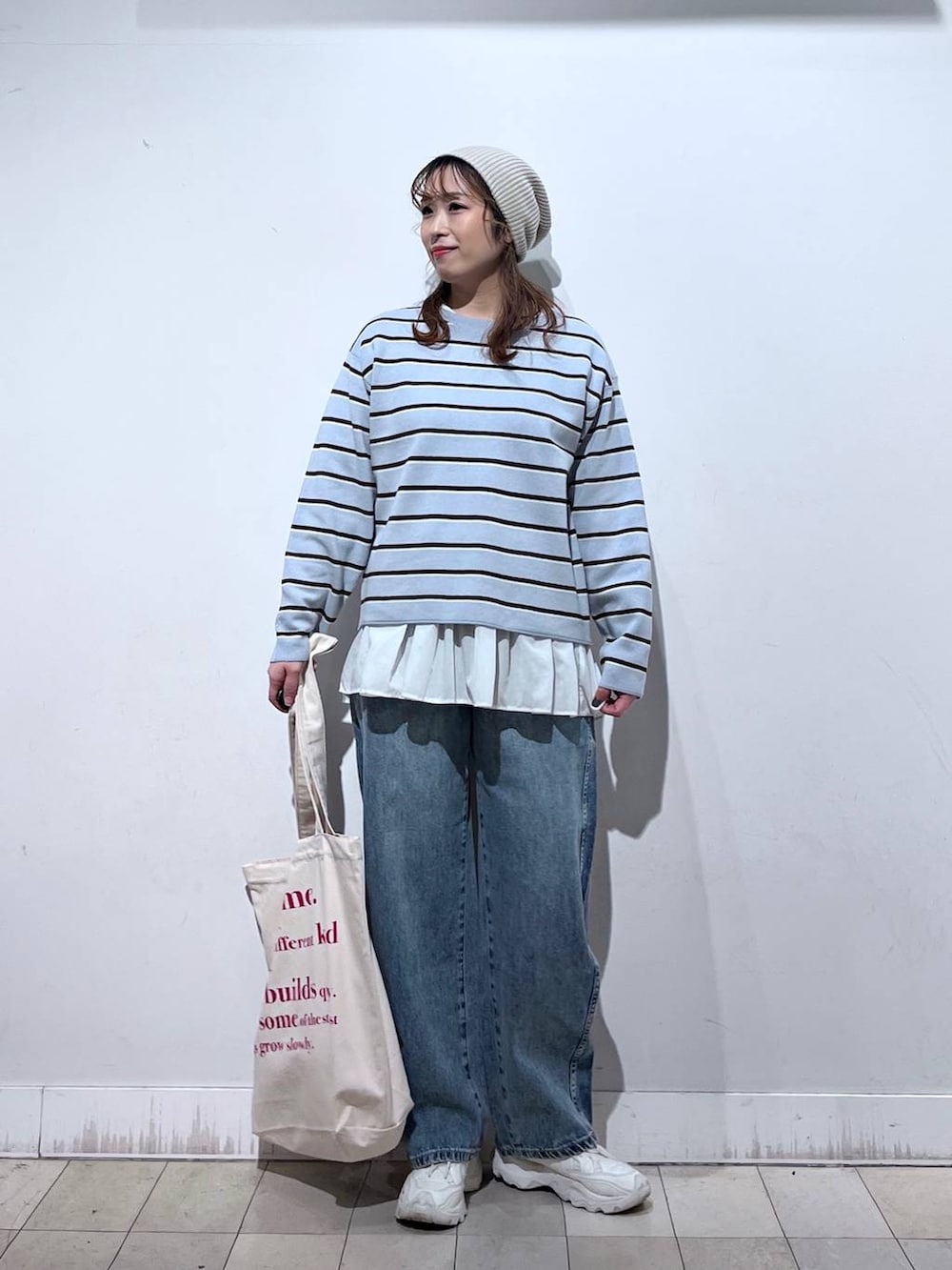 ホワイト系のTシャツ/カットソー、ホワイト系のトートバッグ、ブルー系のニット/セーターを着用したレディースの冬コーディネートの6枚目の写真