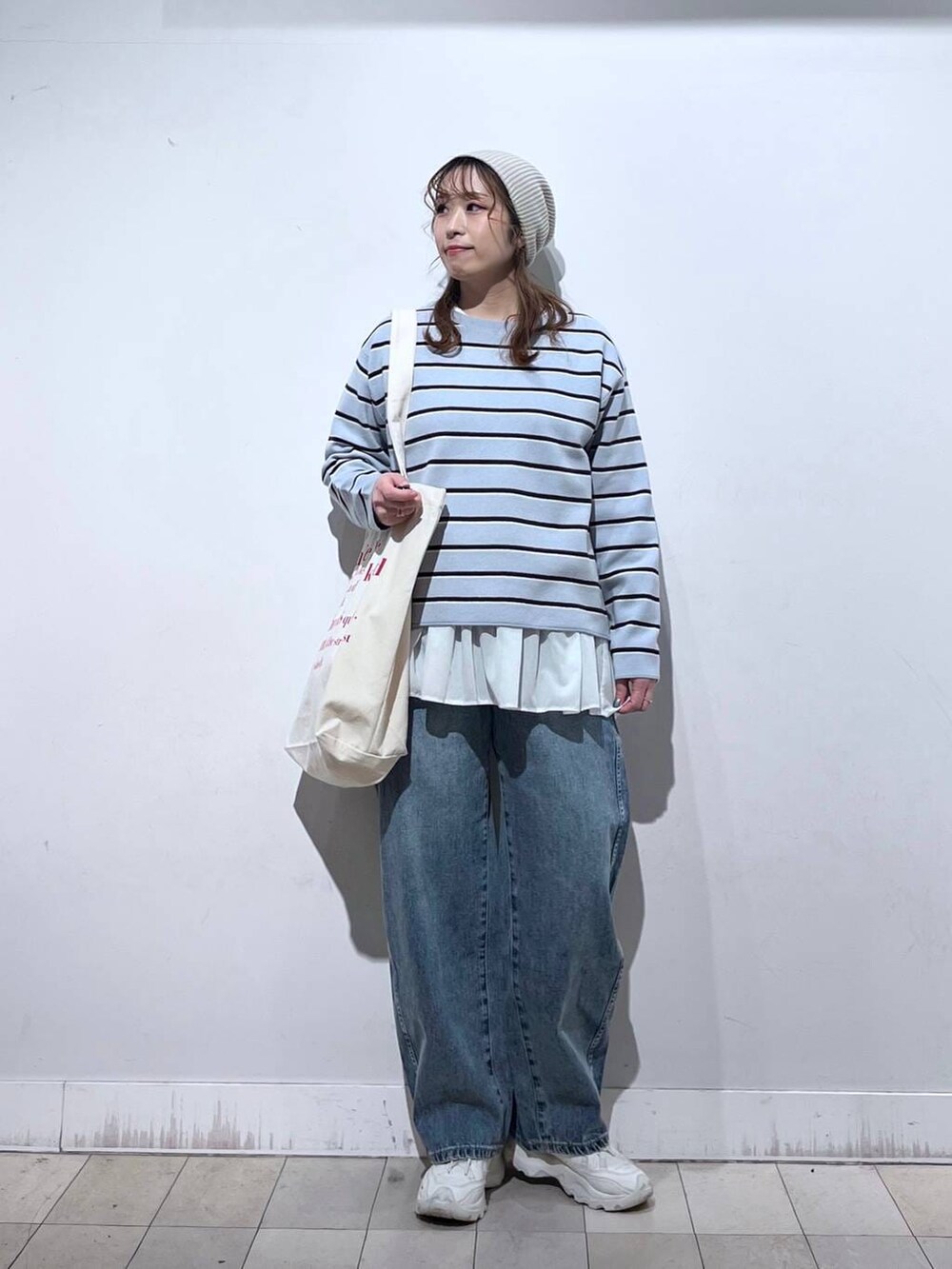 ホワイト系のTシャツ/カットソー、ホワイト系のトートバッグ、ブルー系のニット/セーターを着用したレディースの冬コーディネートの7枚目の写真