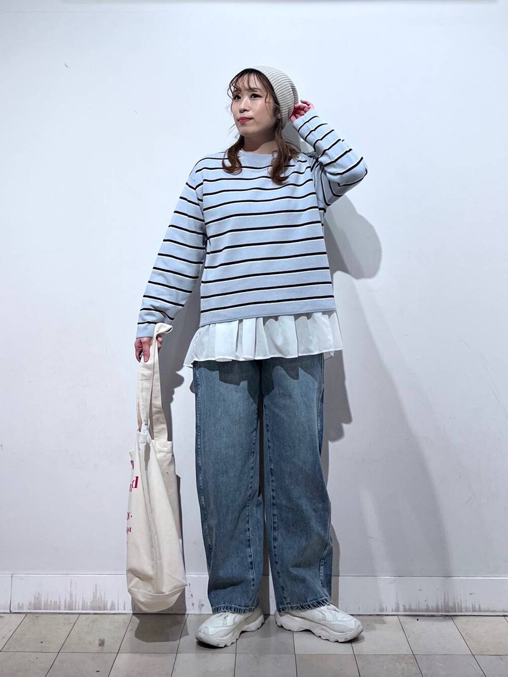 ホワイト系のTシャツ/カットソー、ホワイト系のトートバッグ、ブルー系のニット/セーターを着用したレディースの冬コーディネートの9枚目の写真