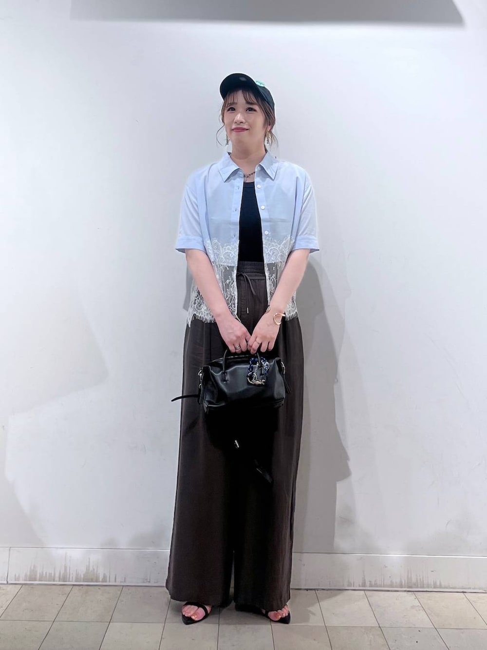 ブラウン系のその他パンツ、ブラック系のボストンバッグ、ブラック系のサンダルを着用したレディースの夏コーディネートの4枚目の写真