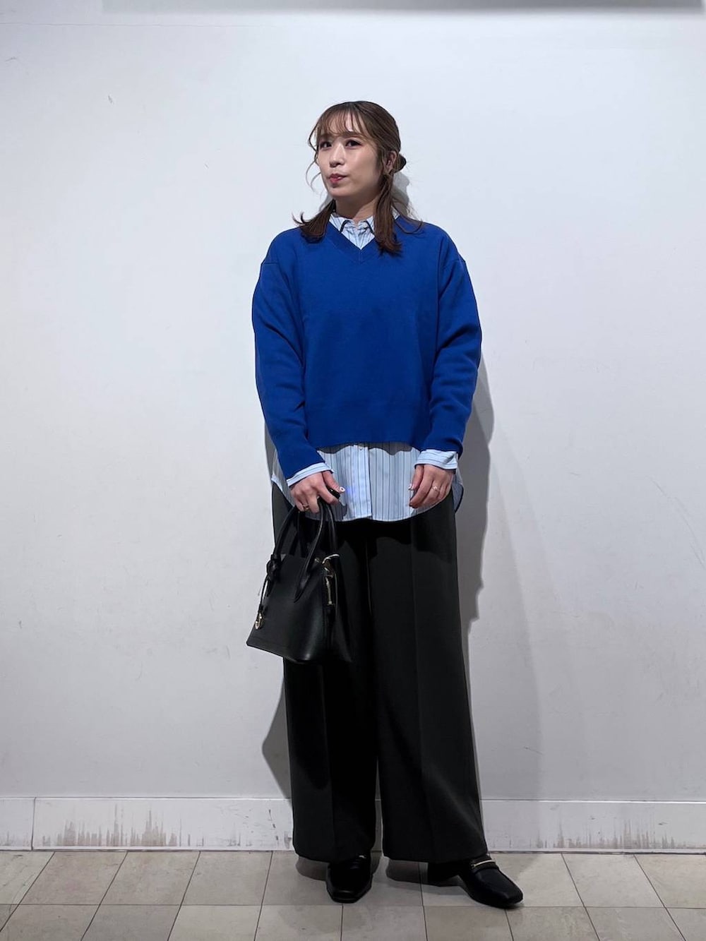 ブラック系のローファー、ブラック系のショルダーバッグ、ブルー系のシャツ/ブラウスを着用したレディースの冬コーディネートの7枚目の写真