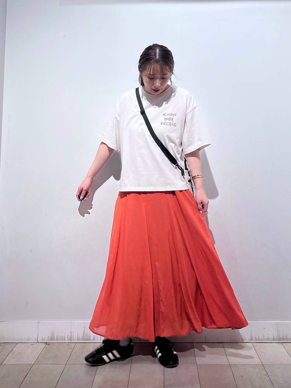 オレンジ系のスカート、ベージュ系のTシャツ/カットソー、ホワイト系のタンクトップを着用したレディースの夏コーディネートの7枚目の写真