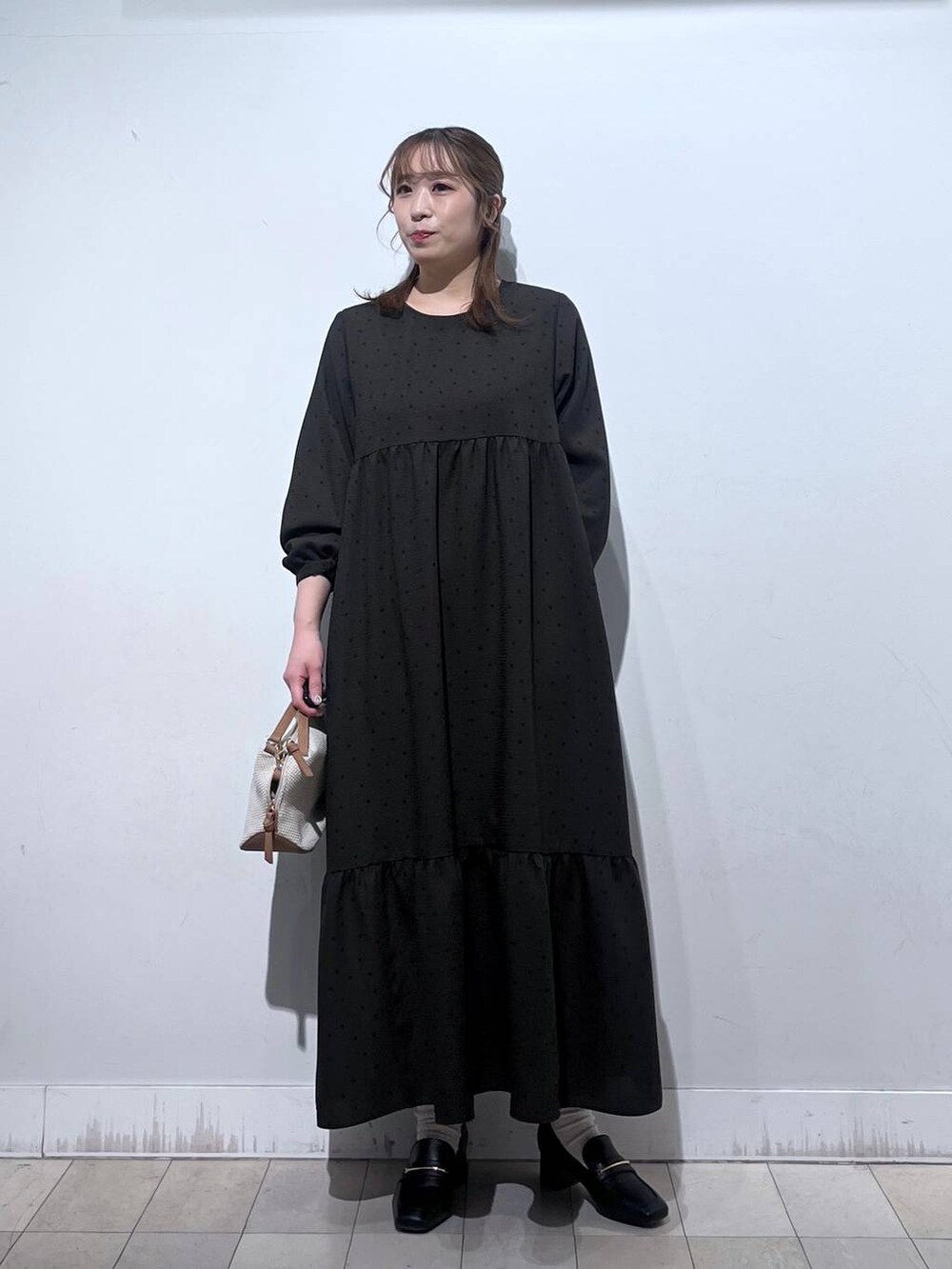 ホワイト系のショルダーバッグ、ブラック系のローファー、ホワイト系のTシャツ/カットソーを着用したレディースの春コーディネートの7枚目の写真